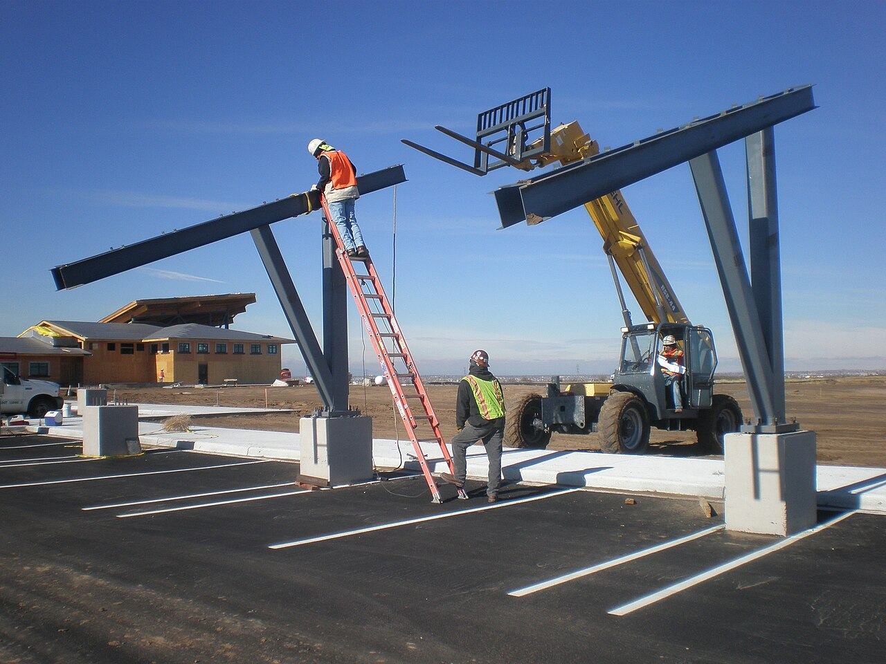 Workers installing photovoltaic panels at a solar array