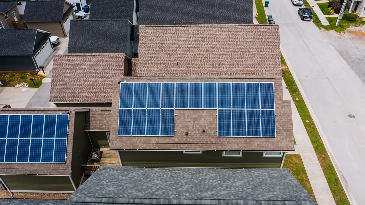 Aerial view of suburban homes with rooftop solar panel arrays
