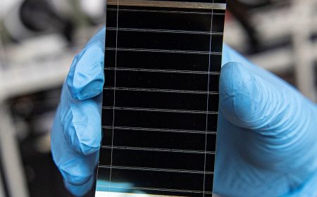 Perovskite solar cell held in a gloved hand in a research laboratory for the perovskite durability article