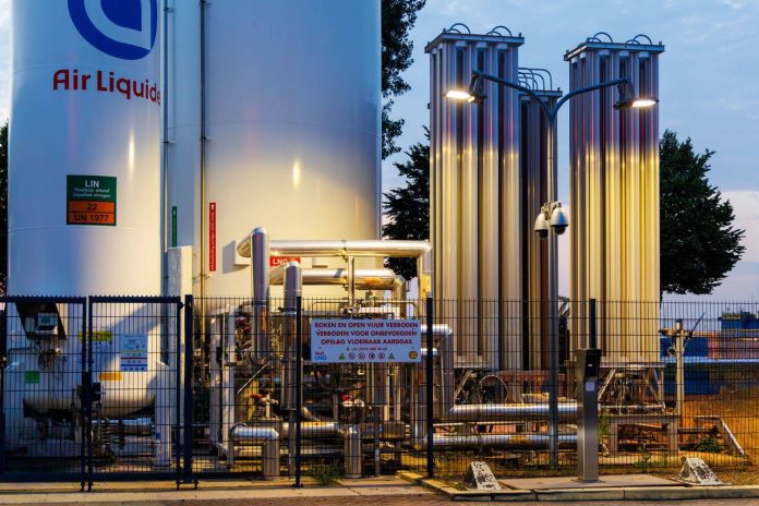 Industrial gas facility with storage tanks at dusk in a port