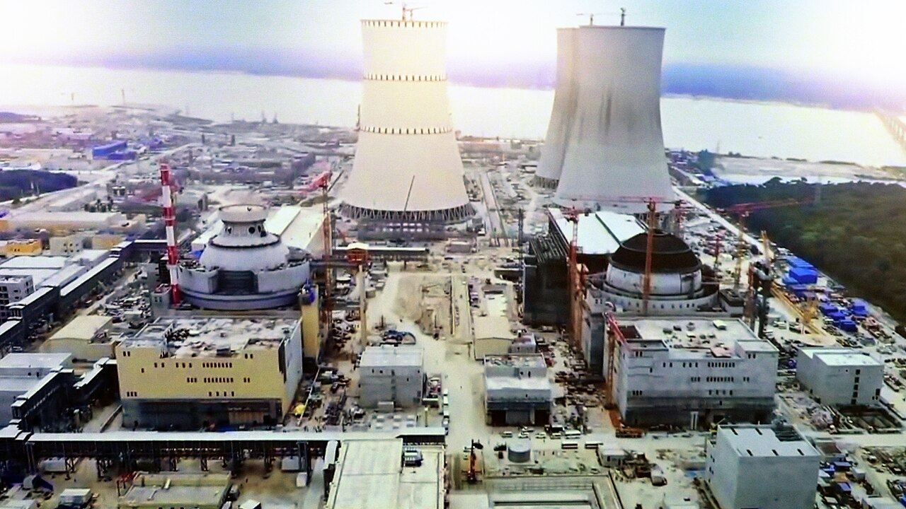 Cooling towers and reactor buildings rising at a nuclear power plant construction site