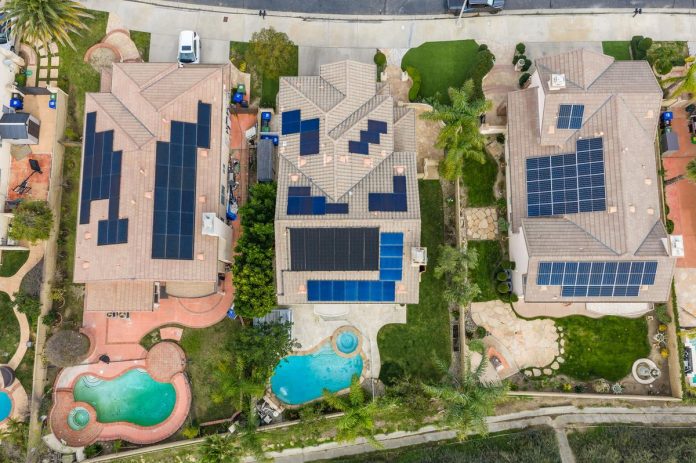 Rooftop solar panels installed on suburban homes viewed from above